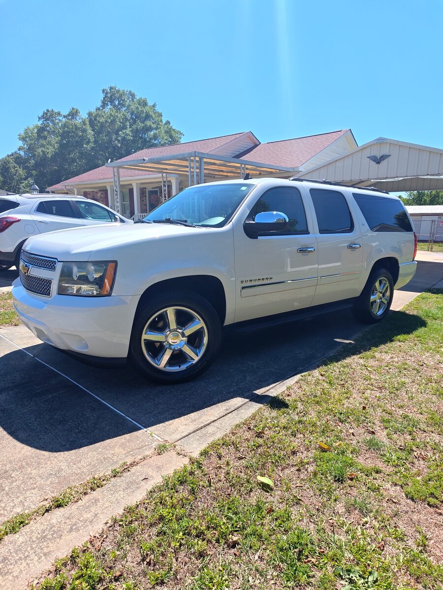 Chevy Suburban LTZ after a full detail — glossy white paint and polished chrome wheels in the sun